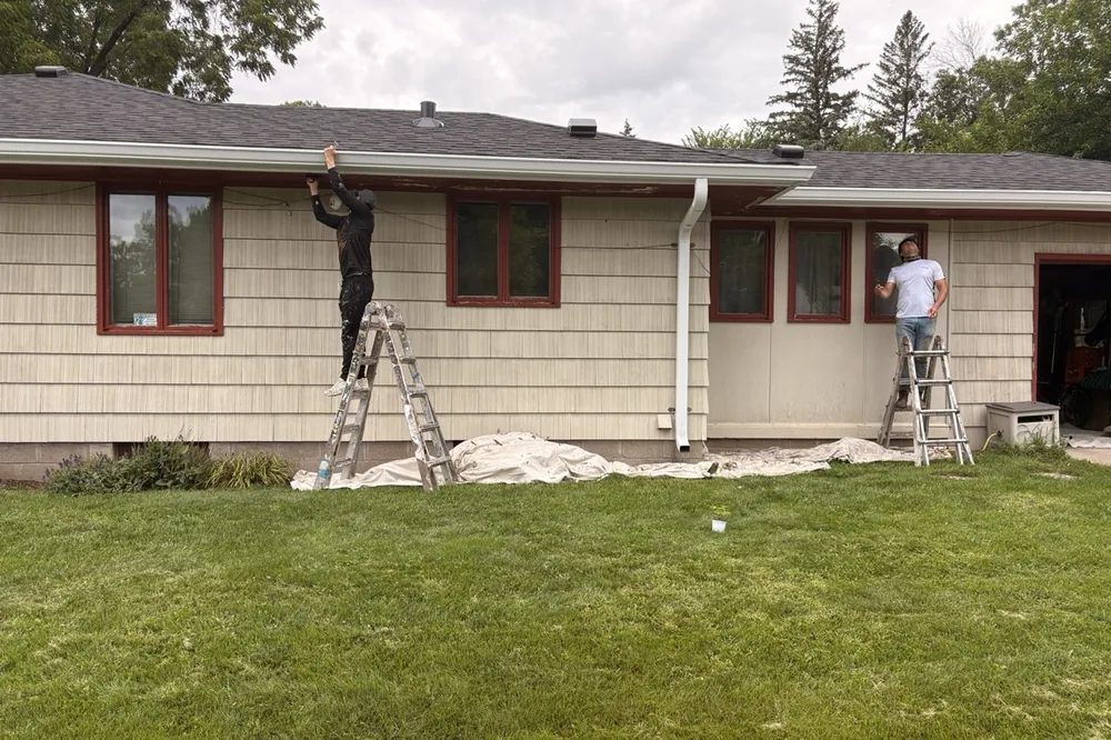 Smooth Painting crew painting the exterior siding and trim of a home